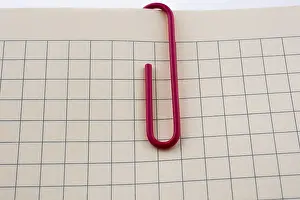 Office Supply Stationery Prints: Colored paper clip on a checked notebook page