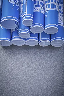 Rolled Up Blueprints Prints: Composition of blue engineering drawings on grey background construction concept