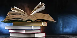Open Book Prints: A composition with an open book lying on a stack of other books