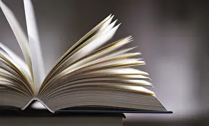 Open Book Prints: A composition with an open book lying on a stack of other books