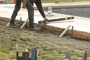 Construction Industry Jobs Prints: Construction worker checking level on wet deck cement