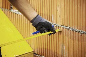 Construction Worker Prints: Construction worker erecting a brick wall in a building shell