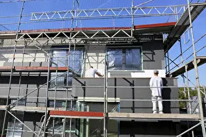 Energy Saving Construction Prints: Construction workers insulate a house facade