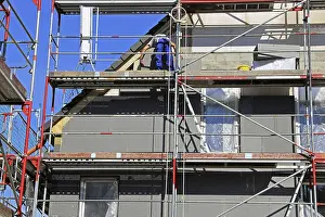 Energy Saving Construction Prints: Construction workers insulate a house facade