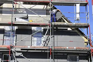 Energy Saving Tips Prints: Construction workers insulate a house facade