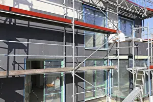 Energy Saving House Prints: Construction workers insulate a house facade