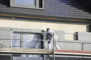 Residential Building Prints: Construction workers insulate a house facade