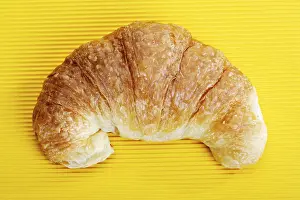 Still Life Photography Prints: Croissant on a yellow surface