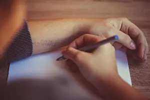 School Child Learning Prints: Cropped shot of student using cheat sheet on math exam