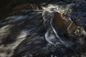 Blurred Motion In Water Prints: Current of a stream with dark water