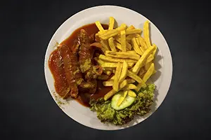 Meat Products Nutrition Prints: Currywurst with chips on a dark background