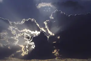 Cloudy Sky View Prints: Un behind dark blue storm clouds