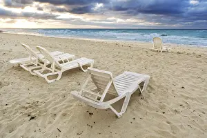 Deserted Beach Prints: Deckchairs on a beach on a background of ocean