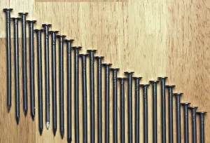Close Up Construction Tools Prints: Declining Graph of Nails on a Wood Background