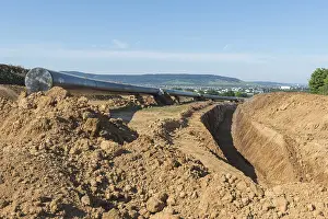 Open Air Landscape Photo Germany Prints: Digging for a pipeline with landscape in the background