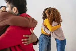 Studio Shot Diversity Prints: Diverse group embracing in a supportive circle
