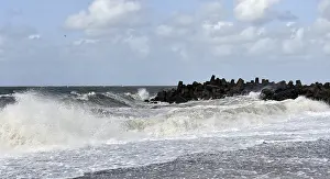 Cloudy Sky Landscape Prints: Dramatic breakwaters hit rocks under a cloudy sky