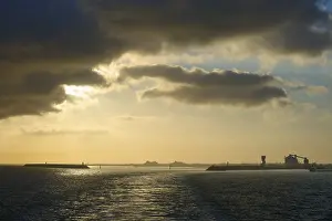 Dramatic Clouds France Prints: Dramatic clouds and setting sun reflect in calm sea