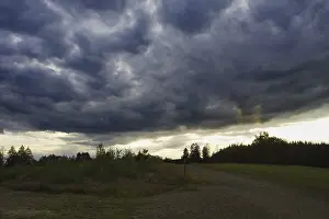 Dramatic Evening Sky Prints: Dramatic, dark clouds drift across a landscape at dusk