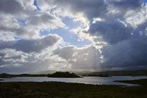 Cloudy Sky With Sun Rays Prints: Dramatic landscape with water and sun rays through clouds in the sky