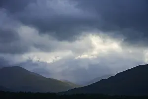 Dramatic Mountain Landscape Prints: Dramatic mountain landscape under cloudy sky with rays of light