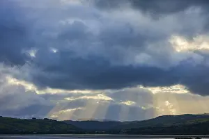 Dramatic Mountain Landscape Prints: Dramatic sky with rays of light breaking through the clouds over a mountainous landscape