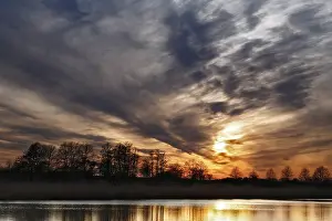Natural Preserve In Eastern Germany Prints: Dramatic sunset sky with trees and soft reflection in water