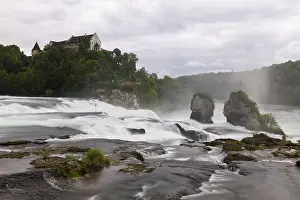 Swiss Tourist Attraction Prints: Dramatic waterfall flows past rocks to a castle