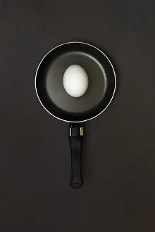 Studio Shot Of Egg Prints: Egg in pan, dark background
