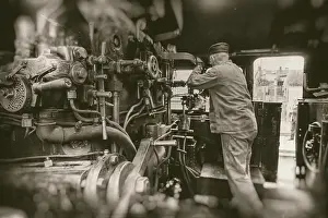 Deserted Railway Station Prints: Engine driver working on steam train engine