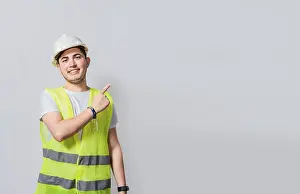 Construction Worker Portrait Prints: Engineer man pointing to side. Builder engineer pointing finger to the right isolated