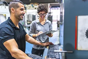 Quality Control Engineer Prints: Engineer and manager talking while using computer in a cnc metallurgic factory
