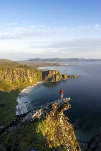 Evening mood, mountaineer standing on a rocky outcrop on the summit of Matind
