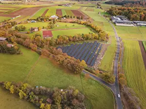 European Renewable Energy Prints: Extensive view of solar systems between fields and autumn trees