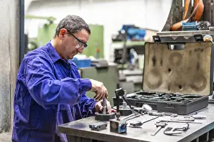 Industrial Building Inspection Prints: Factory worker operator in the numerical control sector checking the equipment