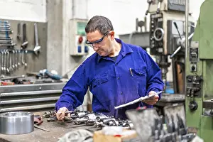 Numerical Control Sector Prints: Factory worker operator in the numerical control sector making a report