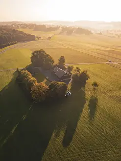Sunset Farm Scene Prints: A farm surrounded by fields and trees in the evening light