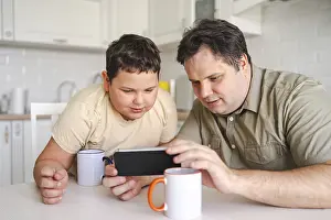 Morning Kitchen Scene Prints: A father and son sit at a kitchen table
