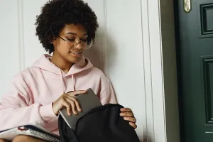 Educational Institution Images Prints: Female student pulls out digital tablet from backpack