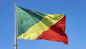 Prints of The flag of Congo flutters in the wind, isolated against a blue sky Related Prints: The Flag of Congo Print