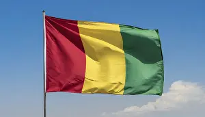 Flag Fluttering In Wind Prints: The flag of Guinea, fluttering in the wind