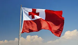 Prints of The flag of Tonga, fluttering in the wind, isolated, against the blue sky Tonga Prints: The Flag of Tonga Print: Blue Sky Background