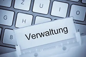 Construction Industry Prints: The folder of a hanging file in front of a computer keyboard on the subject of administration