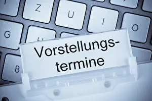 Office Work Prints: The folder of a hanging file in front of a computer keyboard on the subject of presentation dates