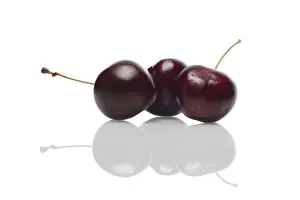 Healthy Eating Nutrition Prints: Three fresh cherries with reflection on glossy surface