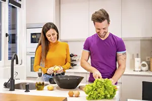 Couple Preparing Salad Prints: Frontal view of a Ccuple preparing a salad together at home