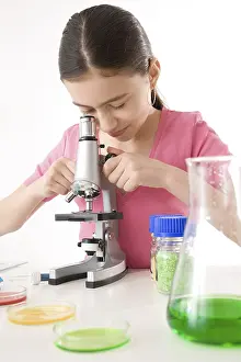 Female Researcher At Work Prints: Girl using a microscope, working in a laboratory
