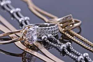 Precious Stones Prints: Gold ring, earrings and chains on a reflective surface