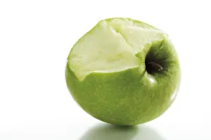 Studio Shot Of Fruit Prints: Green apple which has been bitten into