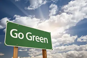 Road Safety Advertising Prints: Go green road sign against dramatic clouds